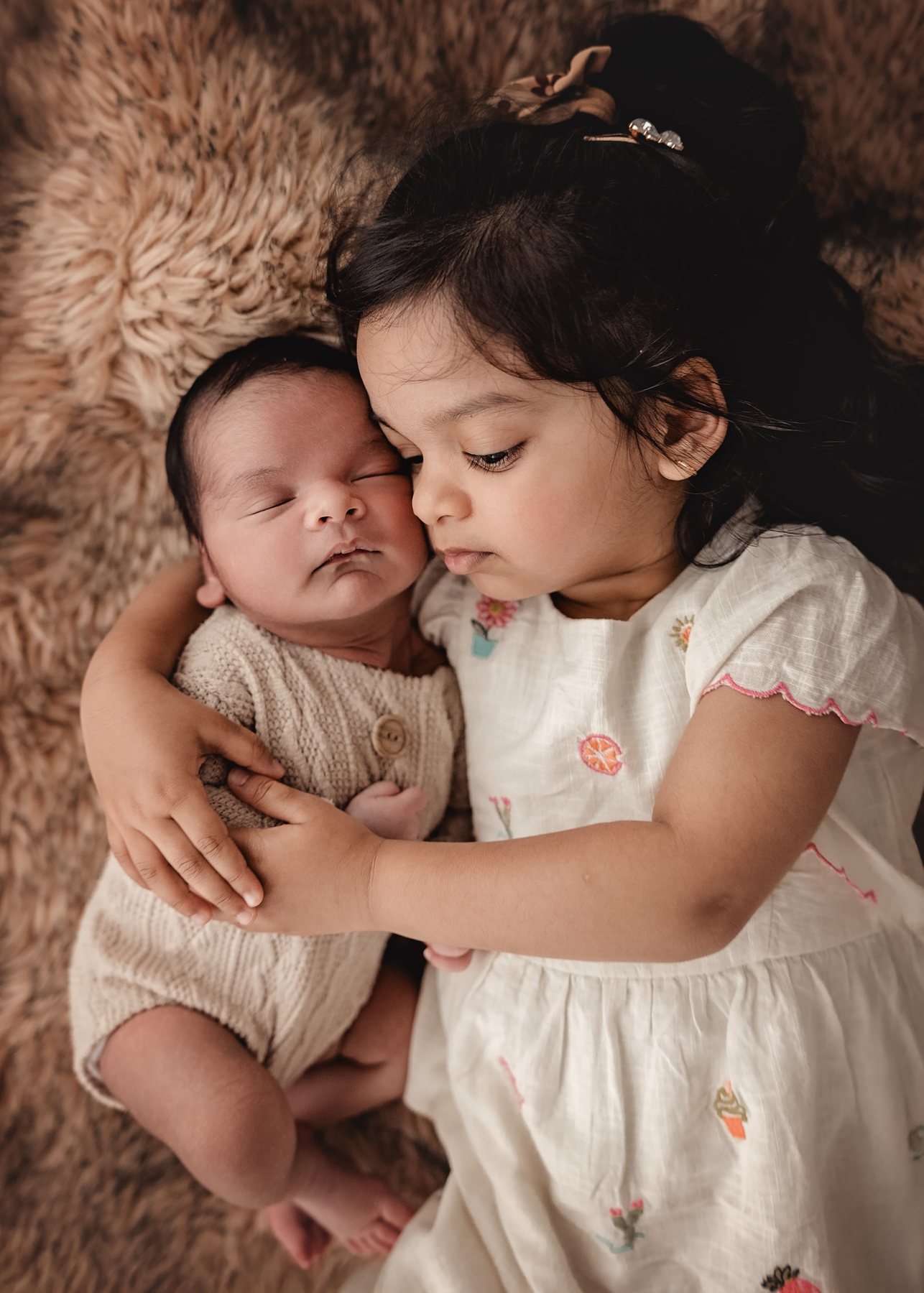 Geschwister kuscheln beim Newbornshooting
