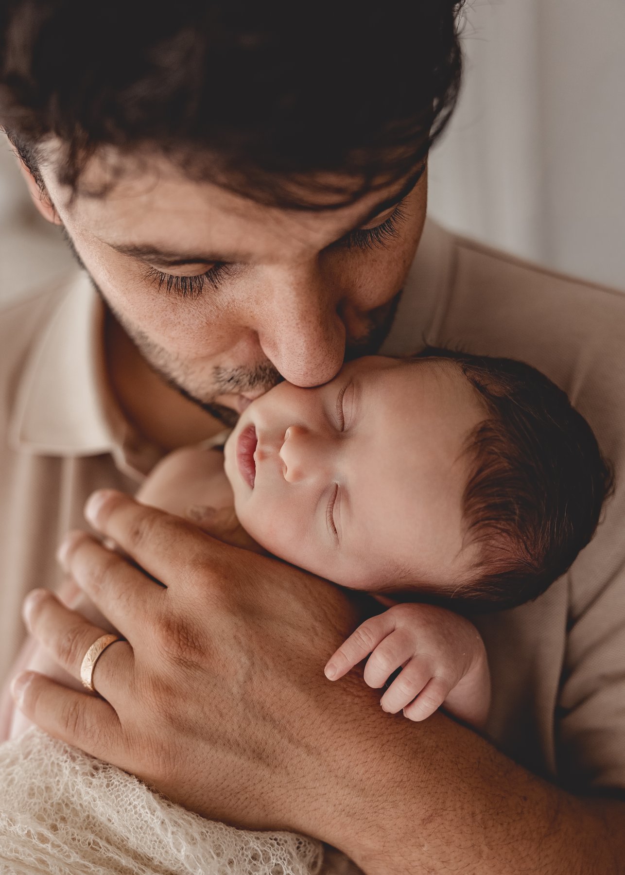 Papa küsst sein Neugeborenes – Newbornshooting bei Nicole Mühlau Fotografie